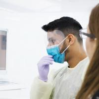 A dentist looking over an x-ray with a patient in a teaching clinic
